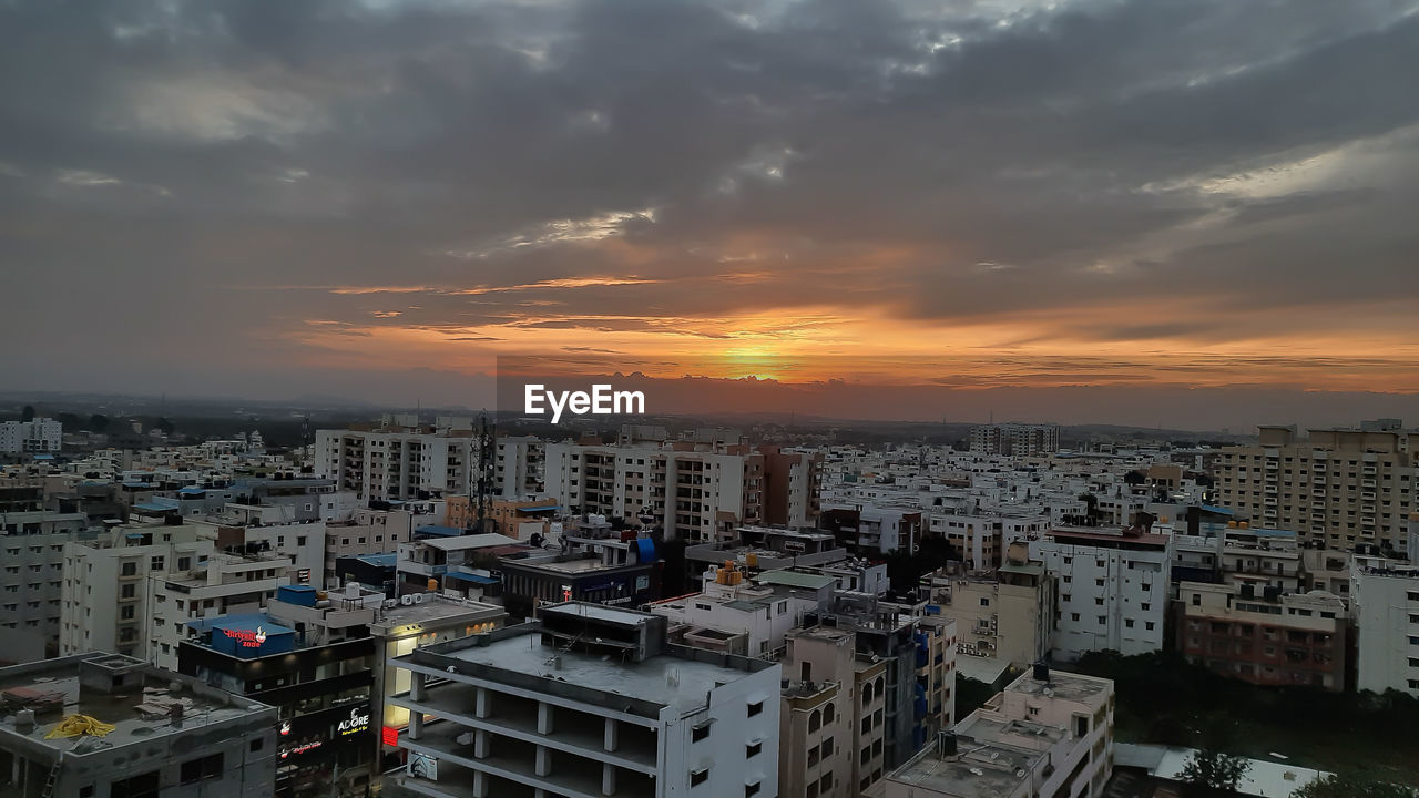 HIGH ANGLE VIEW OF BUILDINGS IN CITY DURING SUNSET