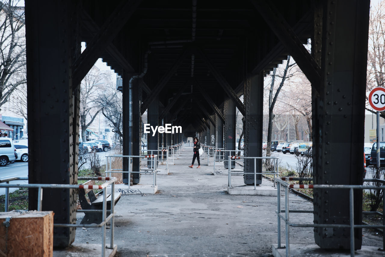 Full length of woman walking under bridge