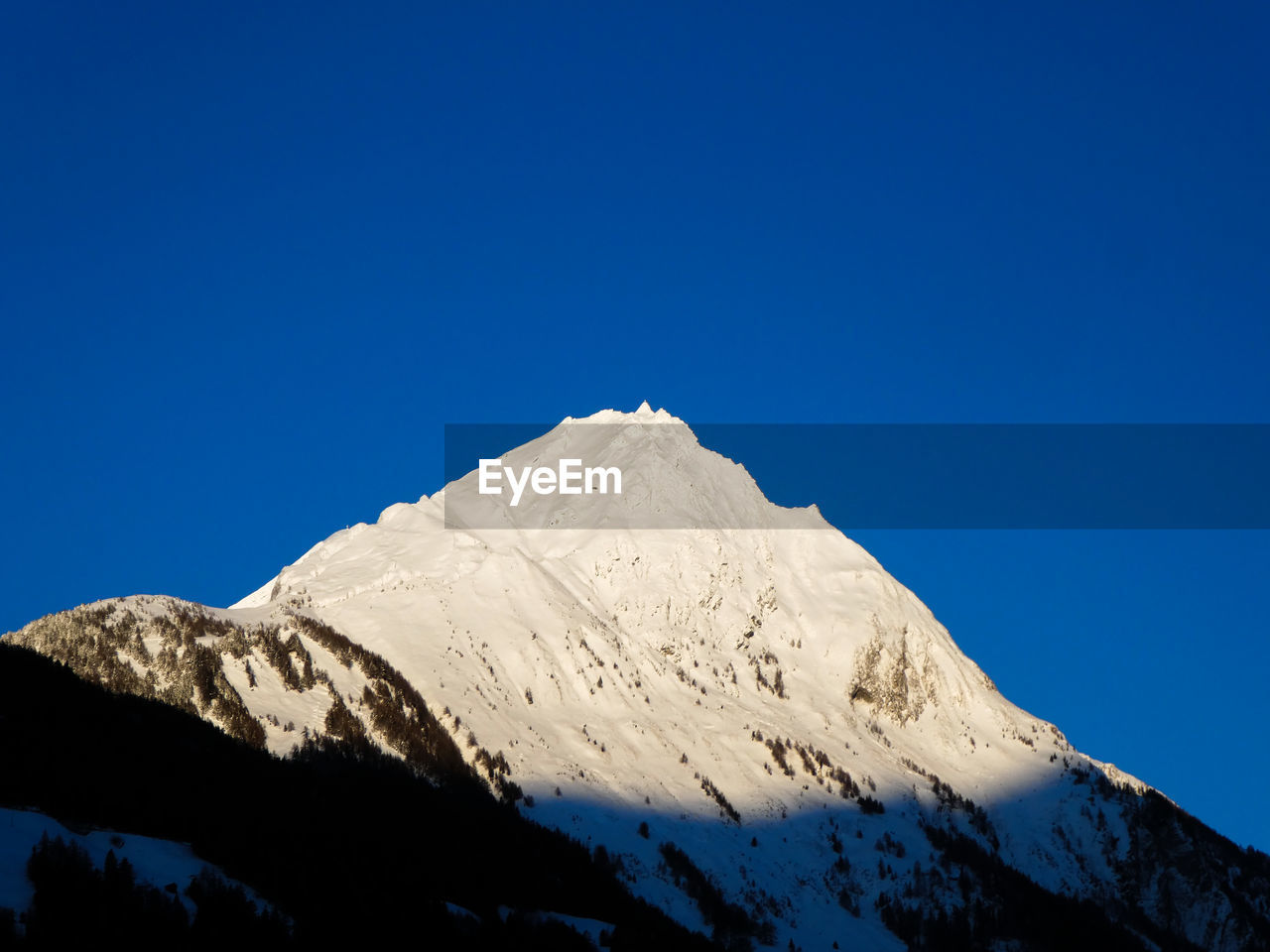 Snowcapped mountains against clear blue sky