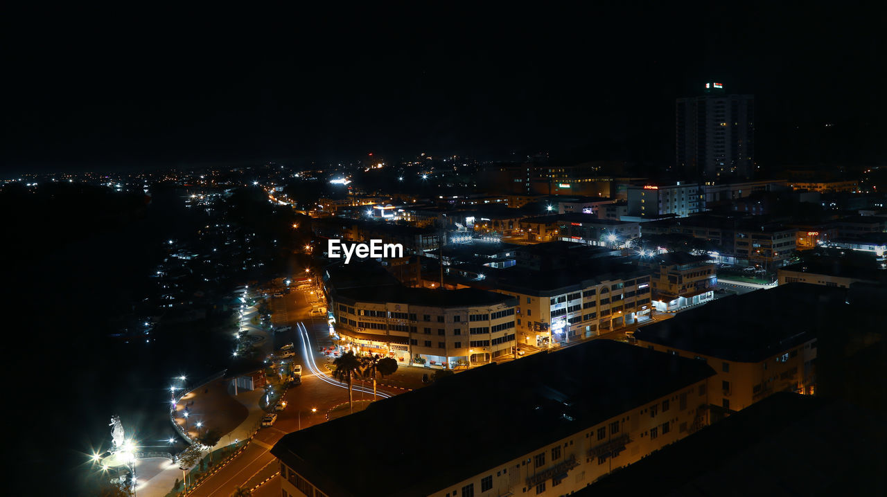 HIGH ANGLE VIEW OF ILLUMINATED CITY BUILDINGS AT NIGHT