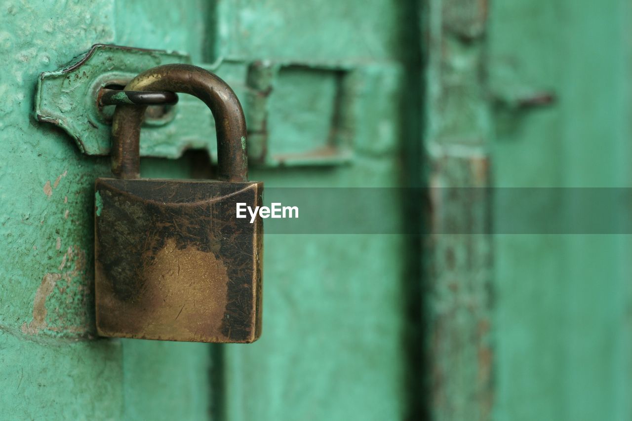 Close-up of padlock on green door