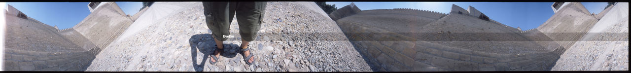 Low section of man standing on rocks