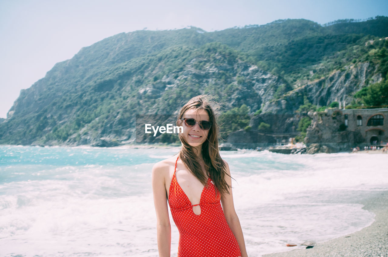 Portrait of young woman wearing red swimsuit on beach