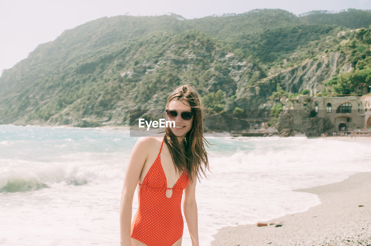 Portrait of young woman wearing red swimsuit on beach