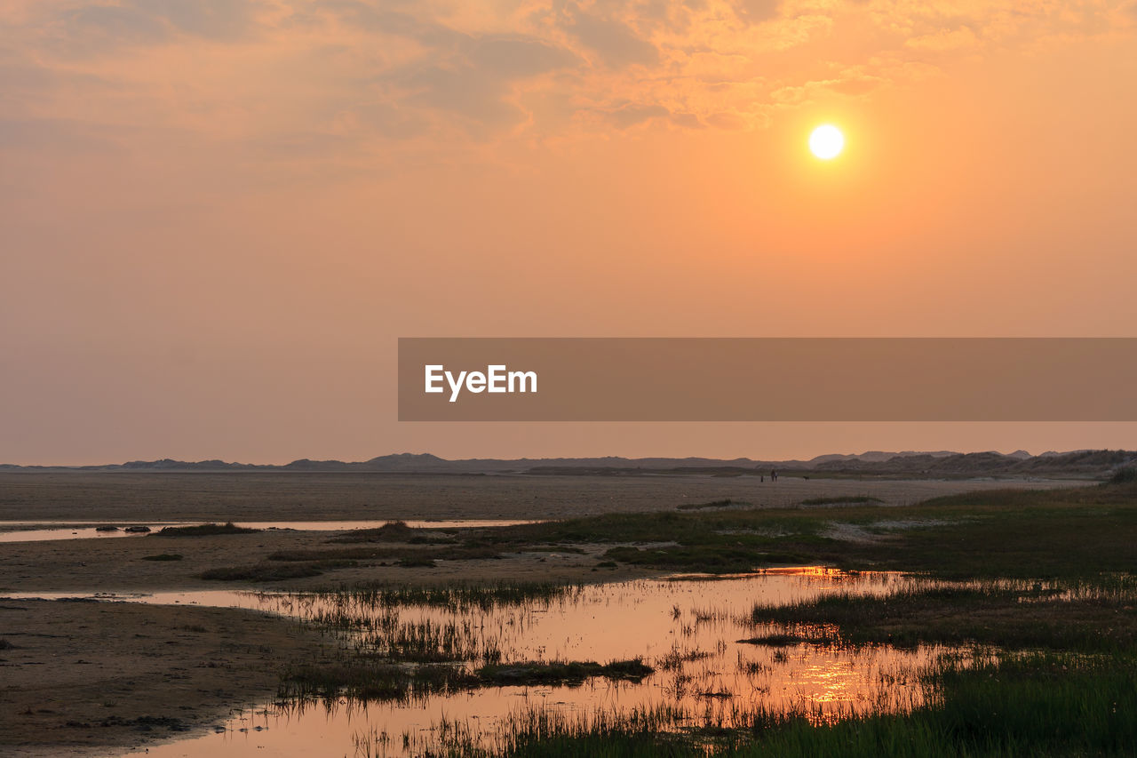 Scenic view of lake against sky during sunset