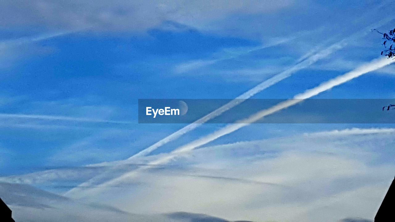 LOW ANGLE VIEW OF VAPOR TRAILS AGAINST SKY