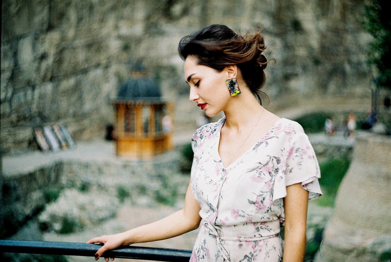 Beautiful young woman standing by railing