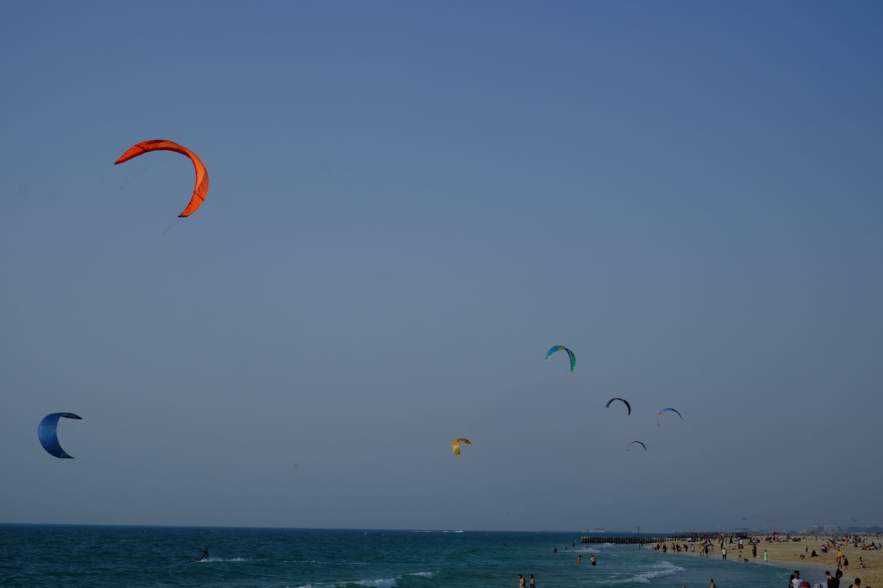 Low angle view of kites flying over sea