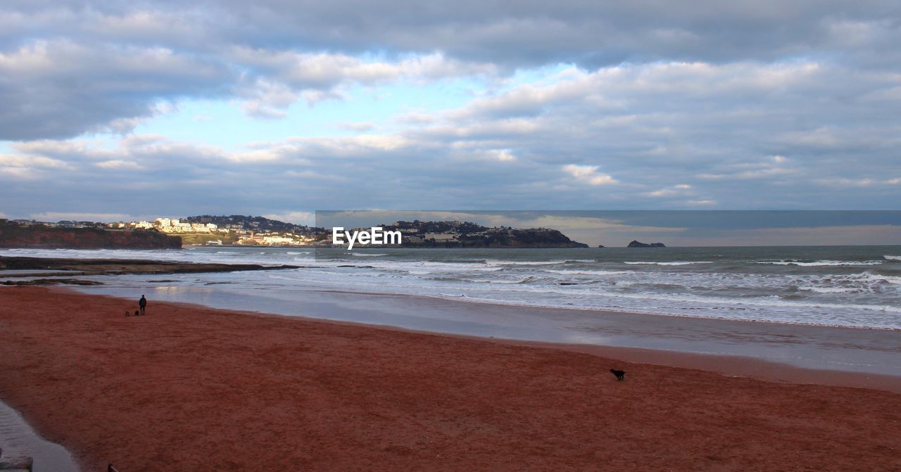 Scenic view of beach against cloudy sky