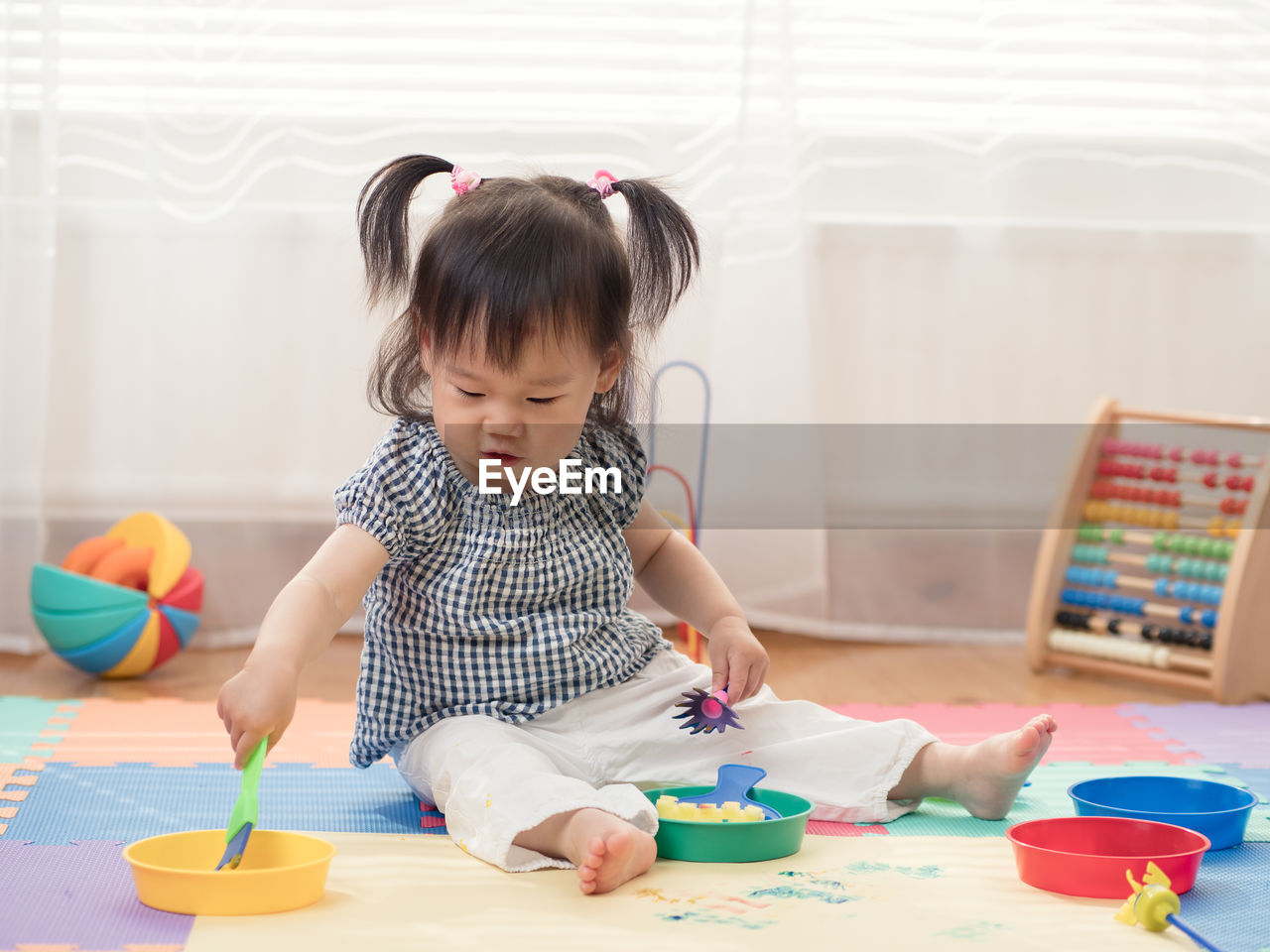 Baby girl playing with toys at home