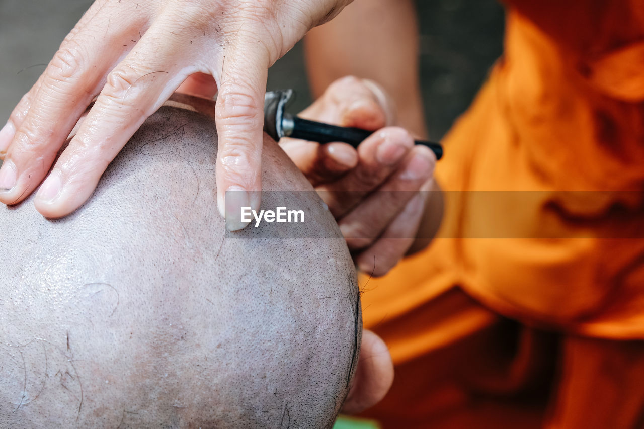 Close-up of man shaving head of boy