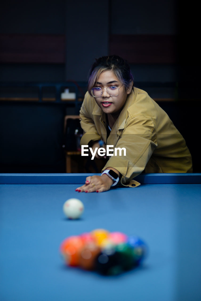 portrait of woman playing pool at home