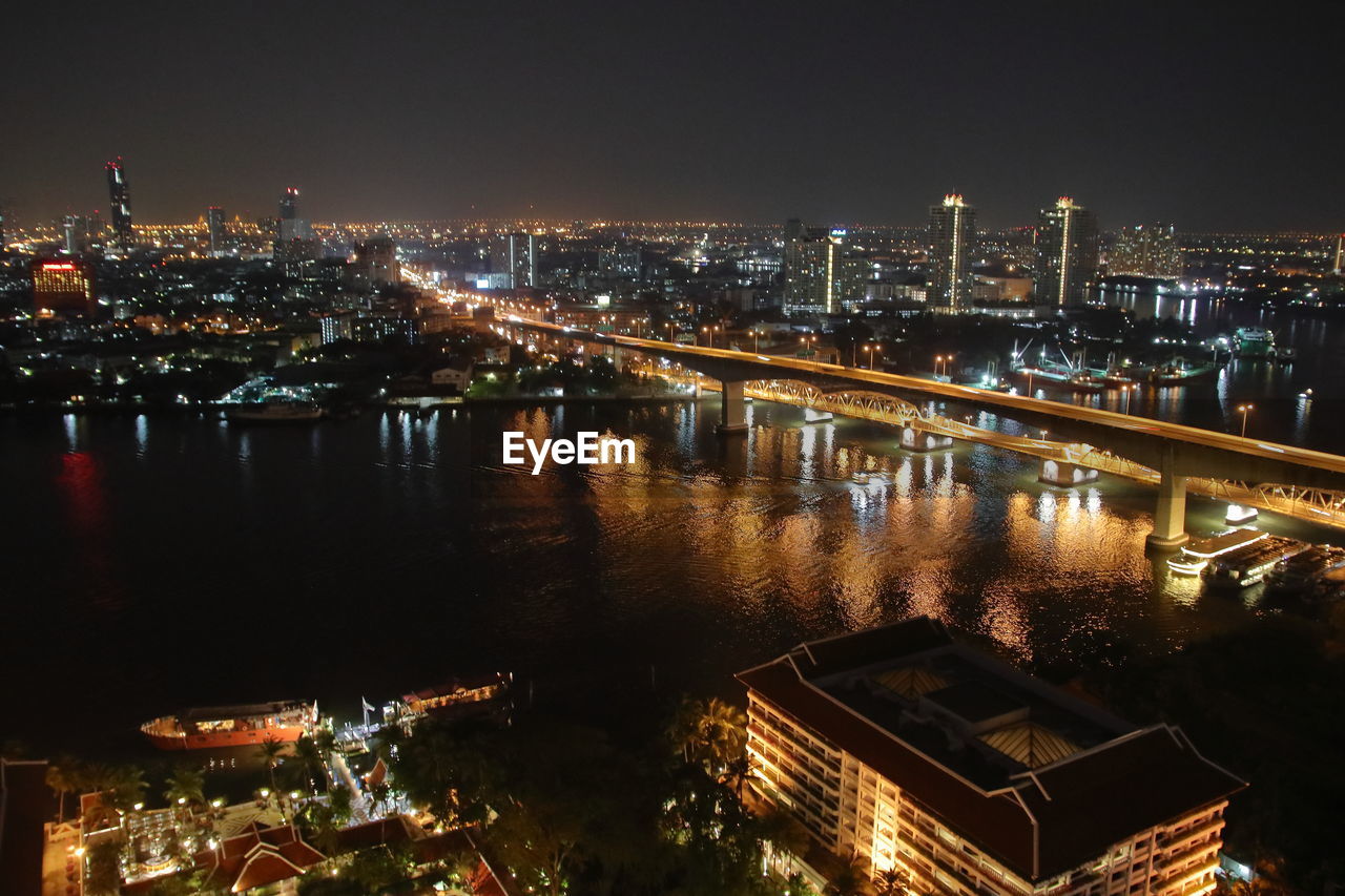 HIGH ANGLE VIEW OF ILLUMINATED BUILDINGS AT NIGHT