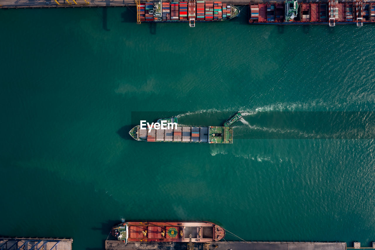 Top view of containers ship floating in sea at shipping port for international import export cargo 