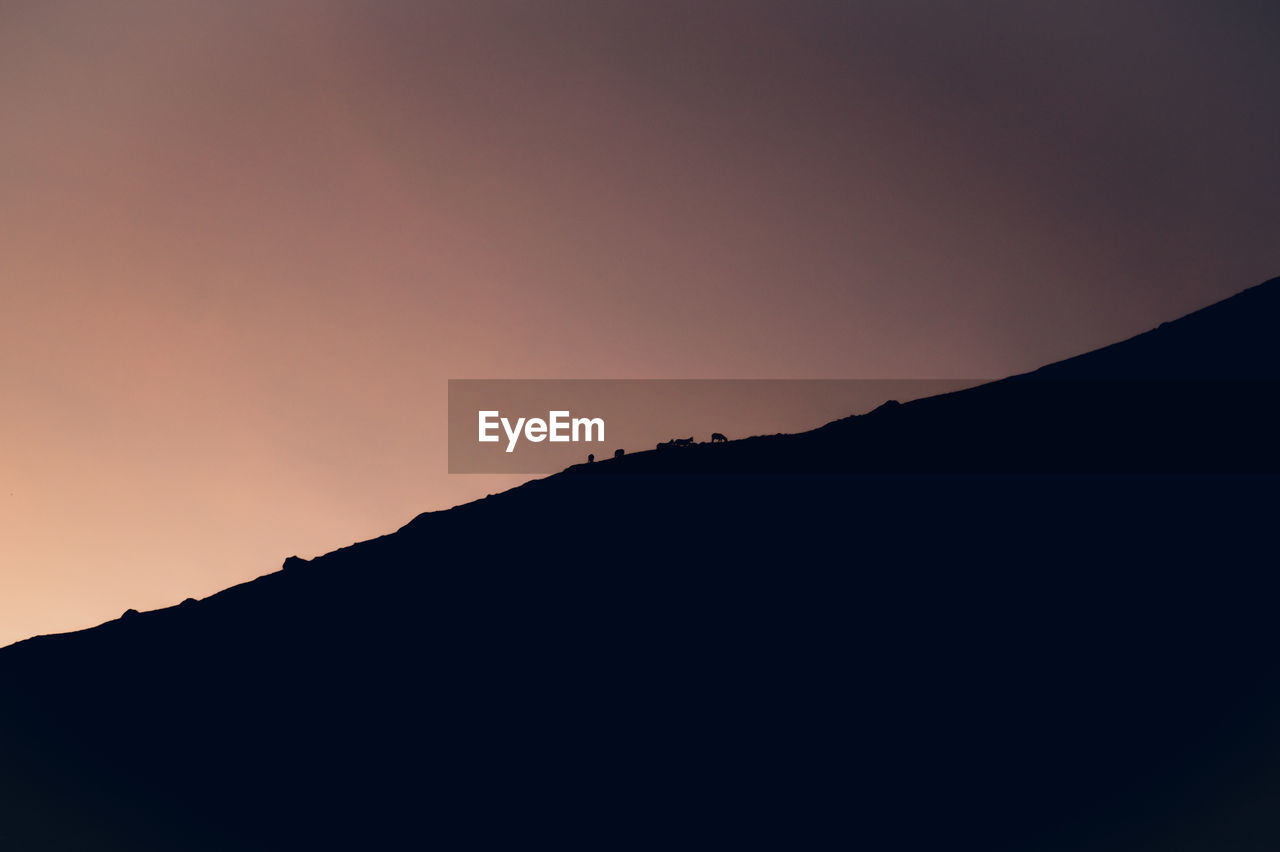 Low angle view of silhouette mountain against sky during sunset