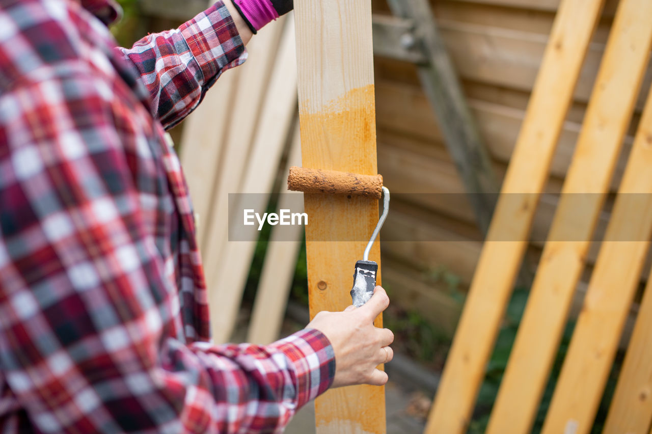 To cover wooden boards with colored varnish with a roller person