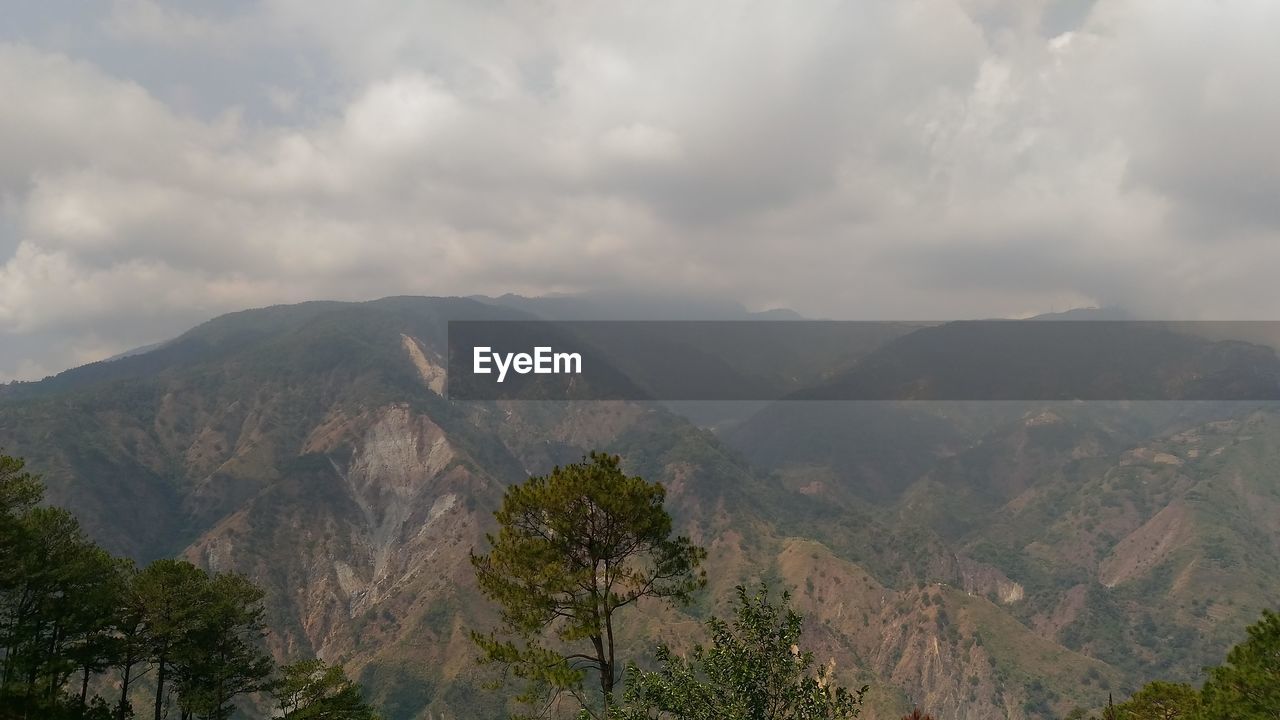 Scenic view of mountains against cloudy sky