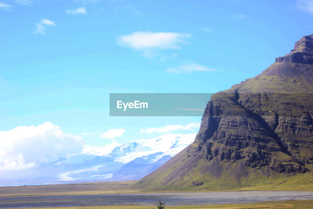 Scenic view of mountain range against cloudy sky