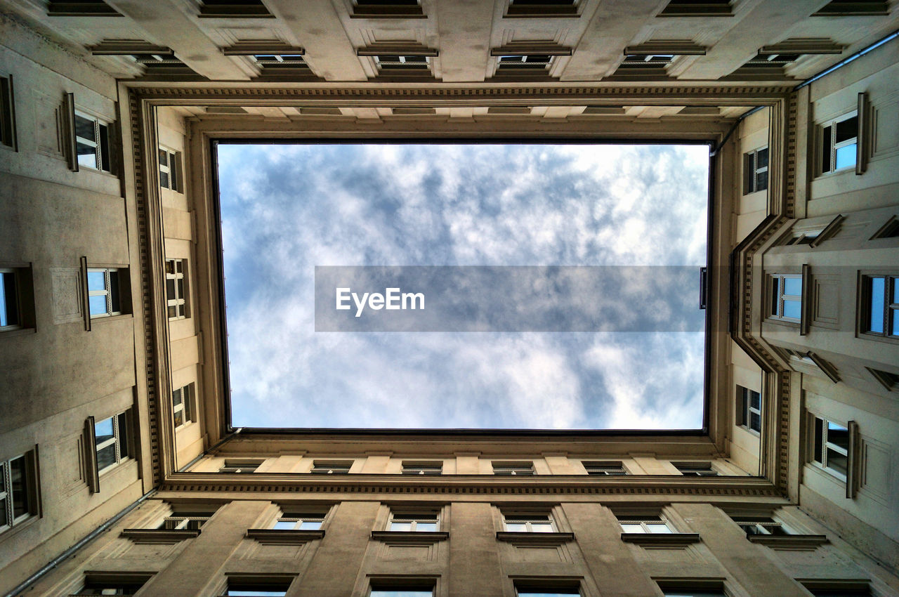 Patio and low angle view of building against sky