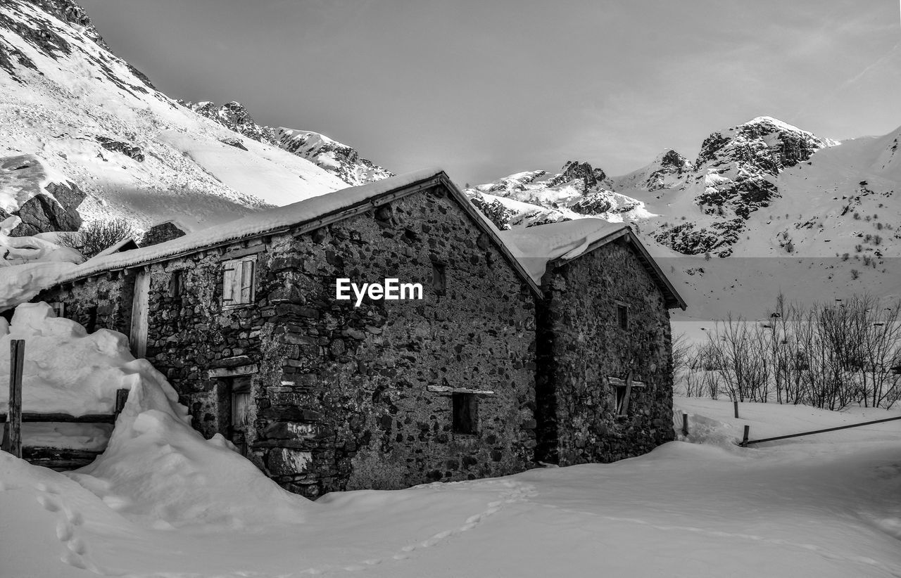 SCENIC VIEW OF SNOW COVERED TREES AND HOUSES AGAINST SKY