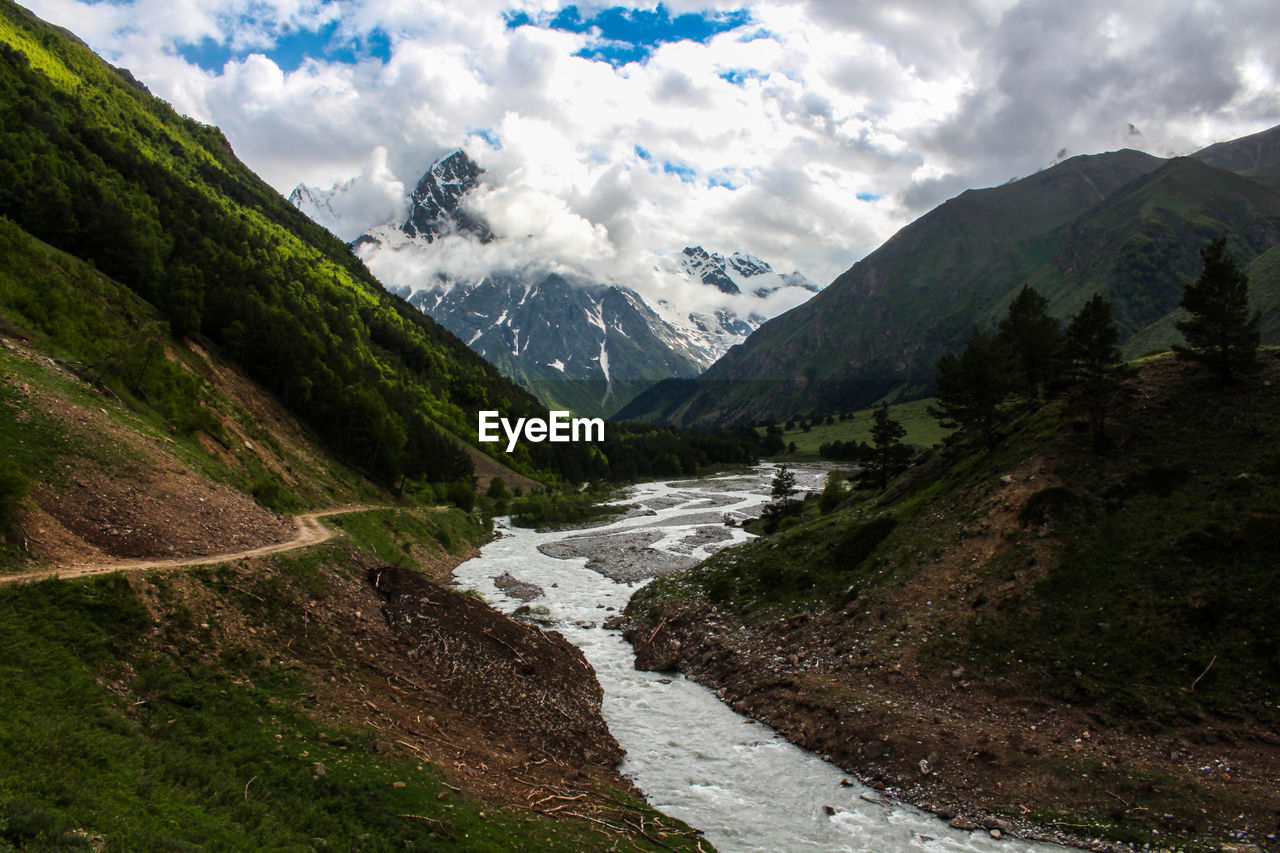 Scenic view of river amidst mountains against sky