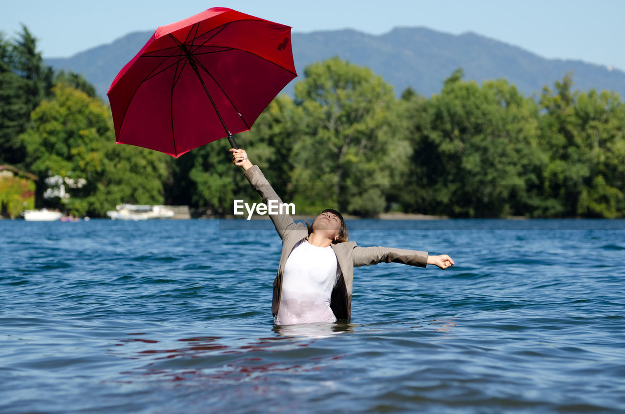 Woman in lake with umbrella