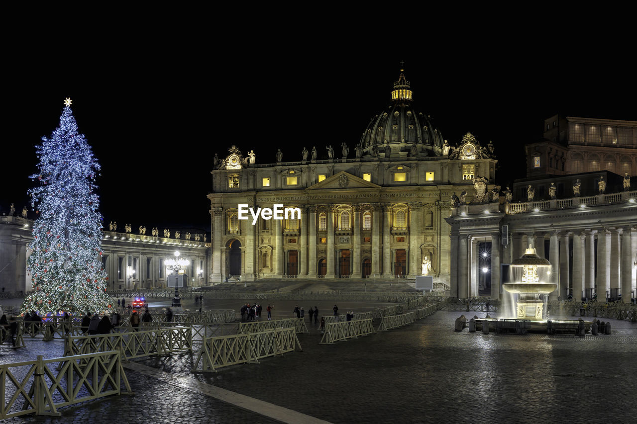 St. peter's basilica decorated with christmas lights and tree. night scene.