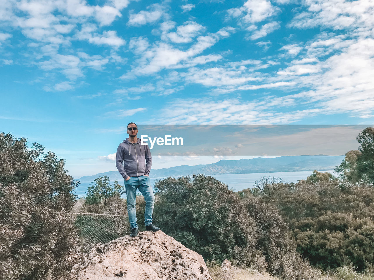 YOUNG MAN STANDING AGAINST SKY