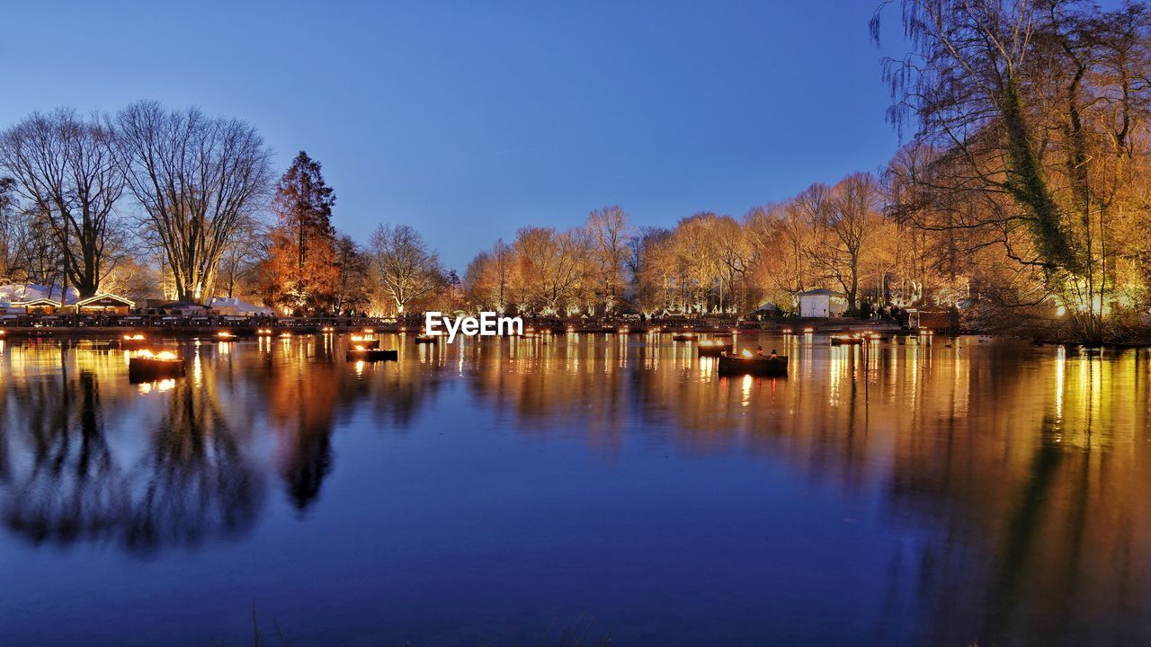 Idyllic view of illuminated lakeshore during blue hour