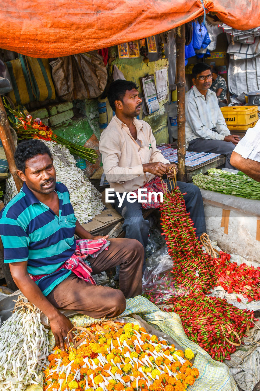 PEOPLE SITTING IN MARKET