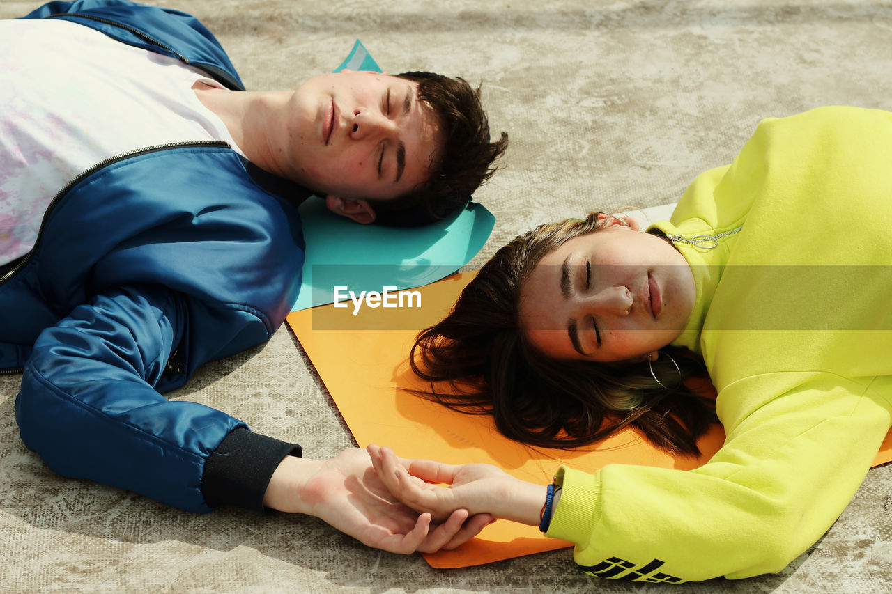 High angle view of friends sleeping on exercise mats