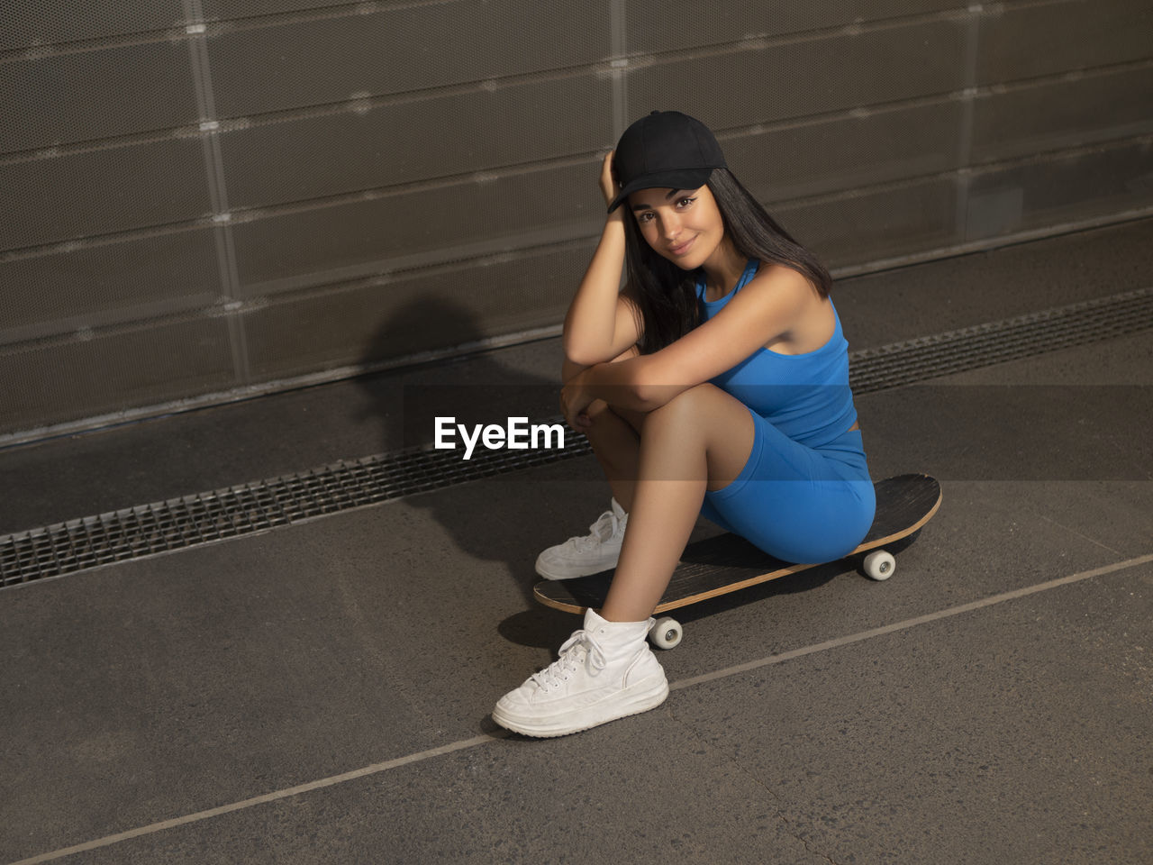 Girl smiles sitting on a skateboard