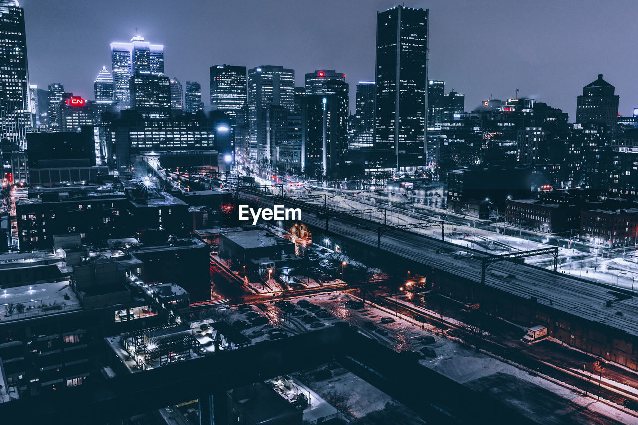 Illuminated cityscape against sky at night