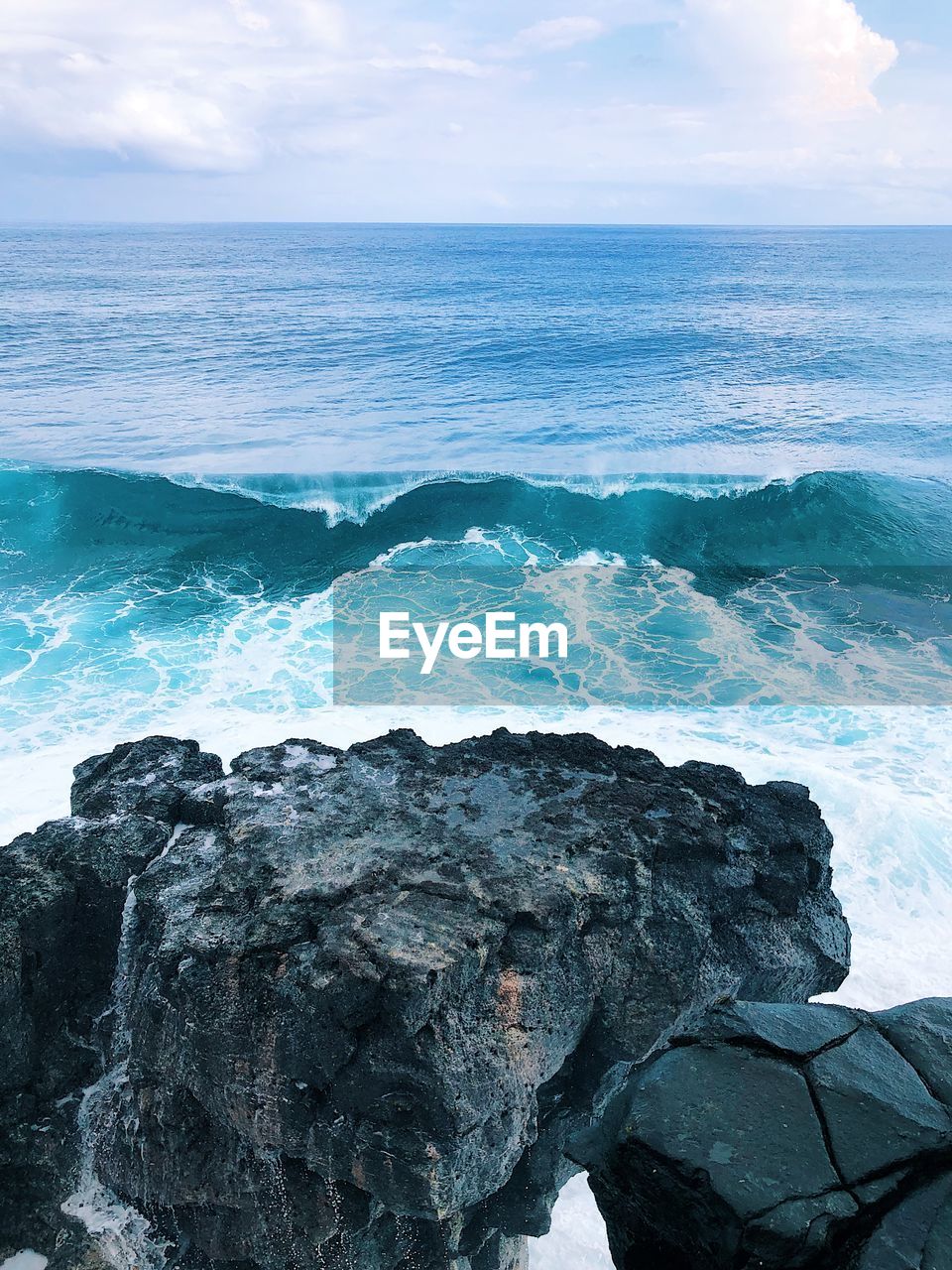 Scenic view of rocks in sea against sky