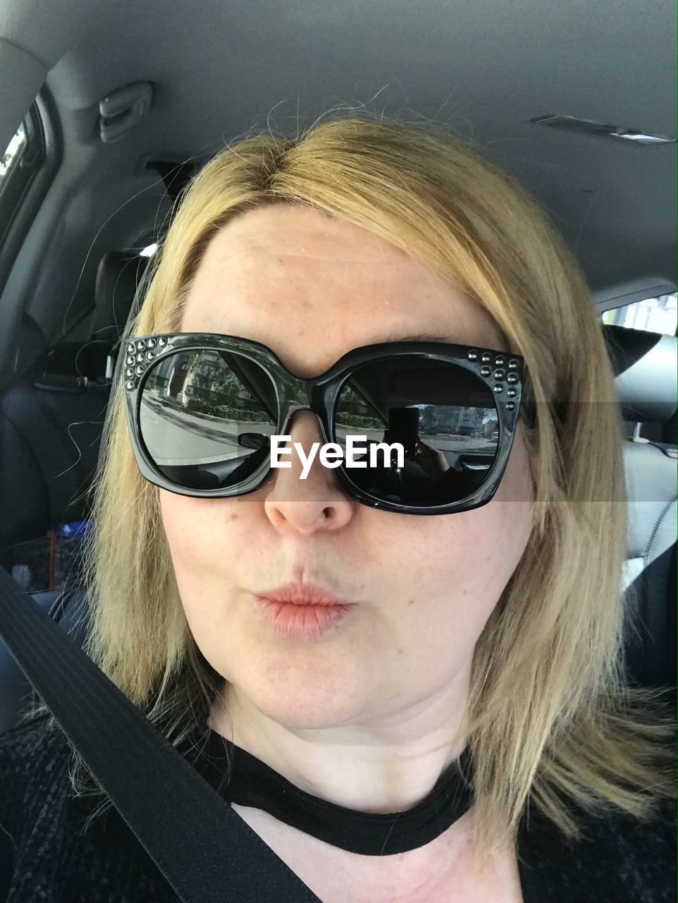 Portrait of woman wearing sunglasses in car