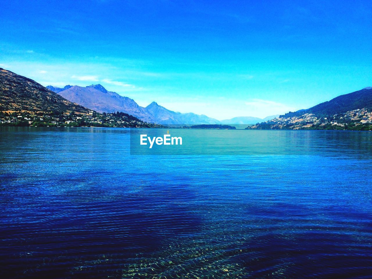 SCENIC VIEW OF LAKE BY MOUNTAIN AGAINST BLUE SKY