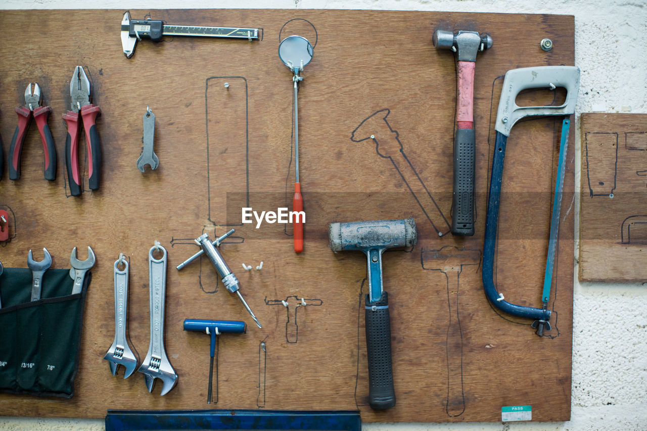 Work tools hanging on wood against wall