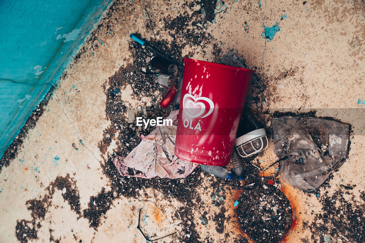 blue, red, high angle view, soil, soft drink, no people, day, art, nature, outdoors, wall, dirt, beach, land, sand