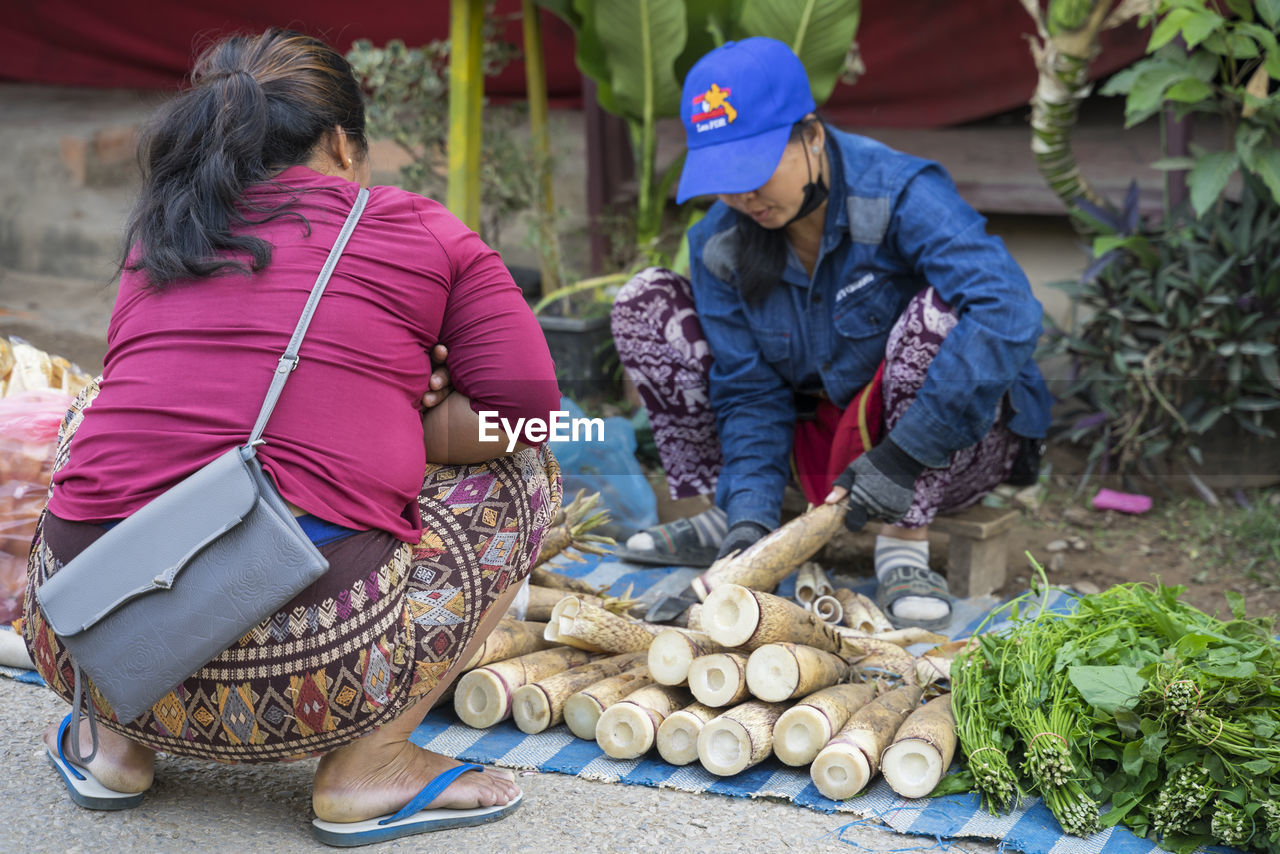 REAR VIEW OF PEOPLE HAVING FOOD