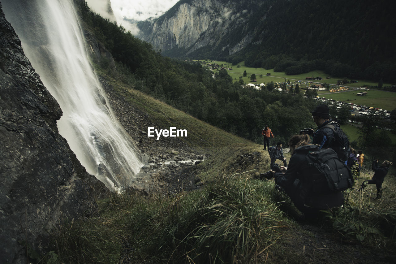 PEOPLE STANDING ON MOUNTAIN IN FOREST