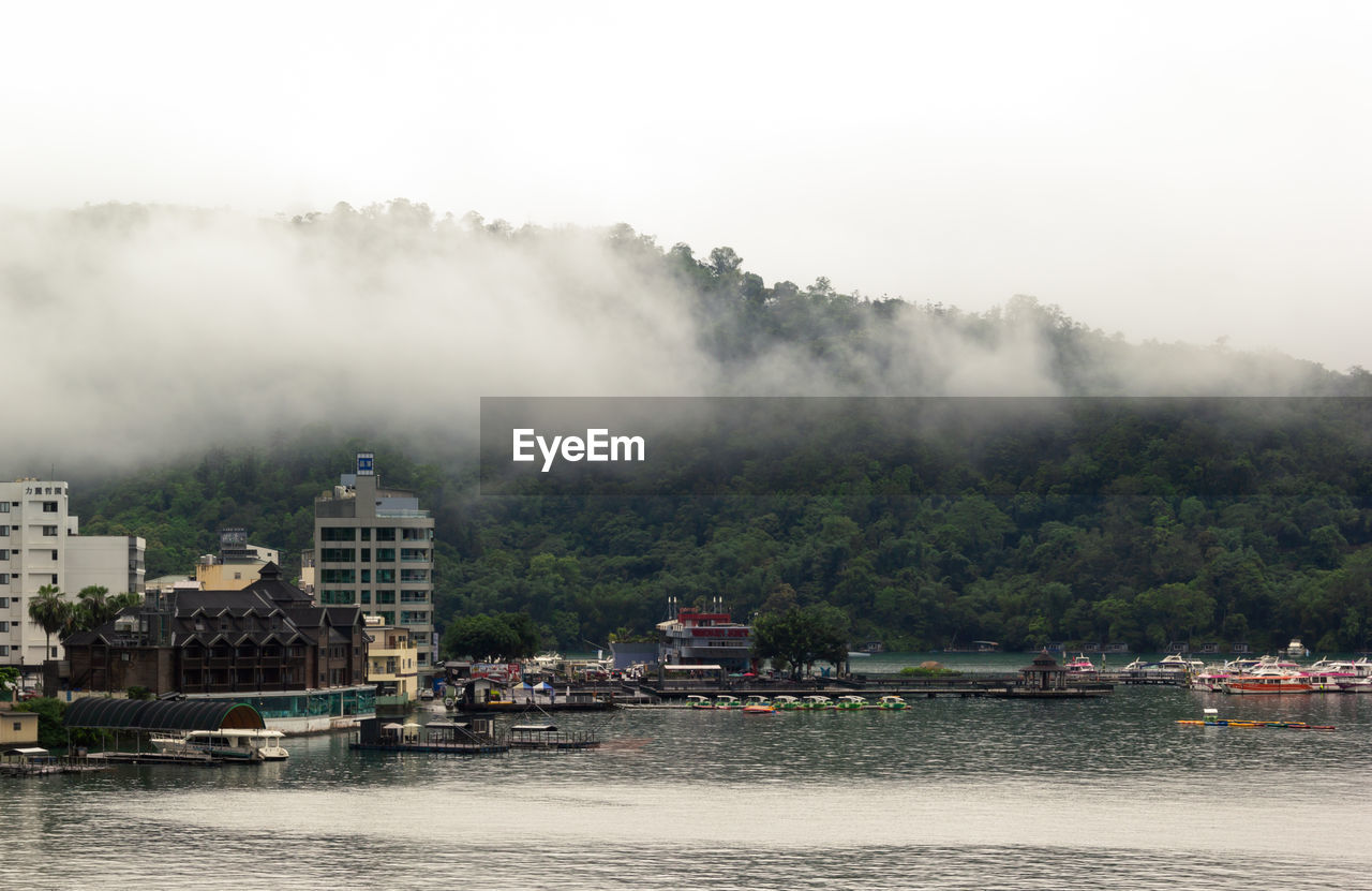 Scenic view of waterfront at sun moon lake with fog covering mountain