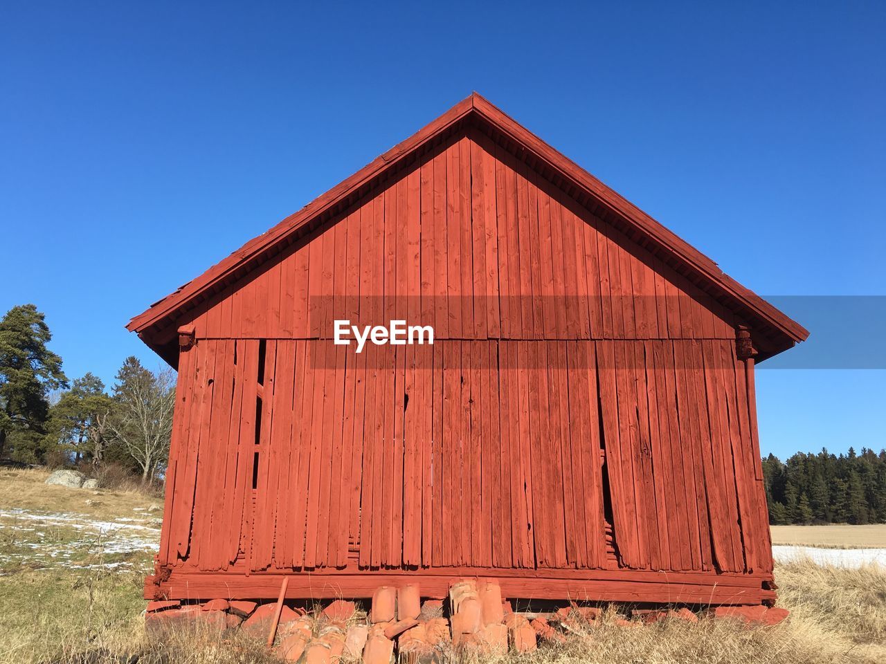 Old barn on field against clear sky