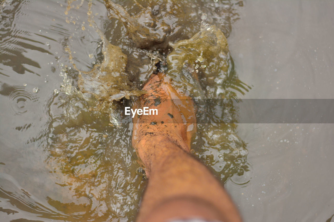 Low section of man legs in dirty water