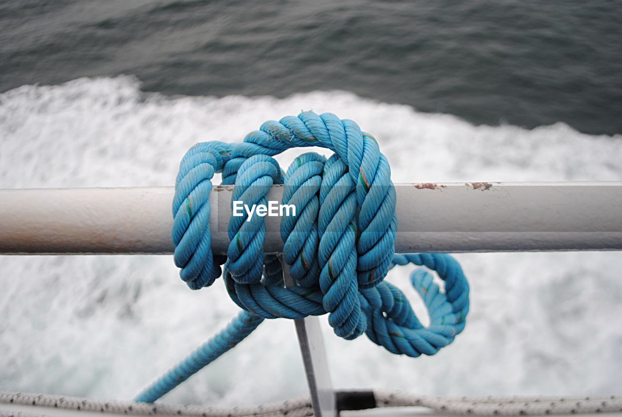 Close-up of rope tied to sailboat in sea