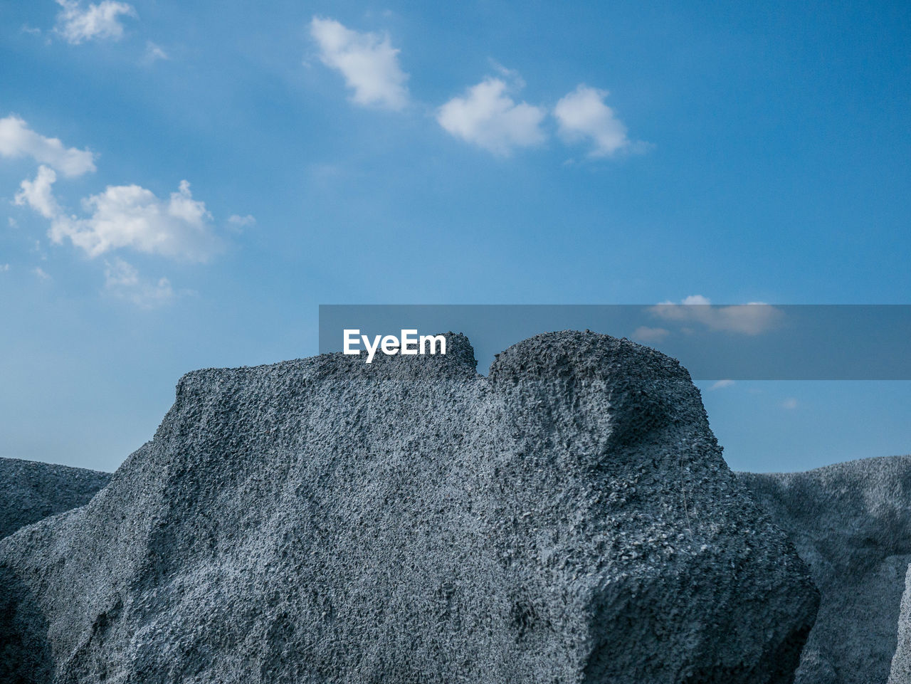 LOW ANGLE VIEW OF ROCKS AGAINST BLUE SKY