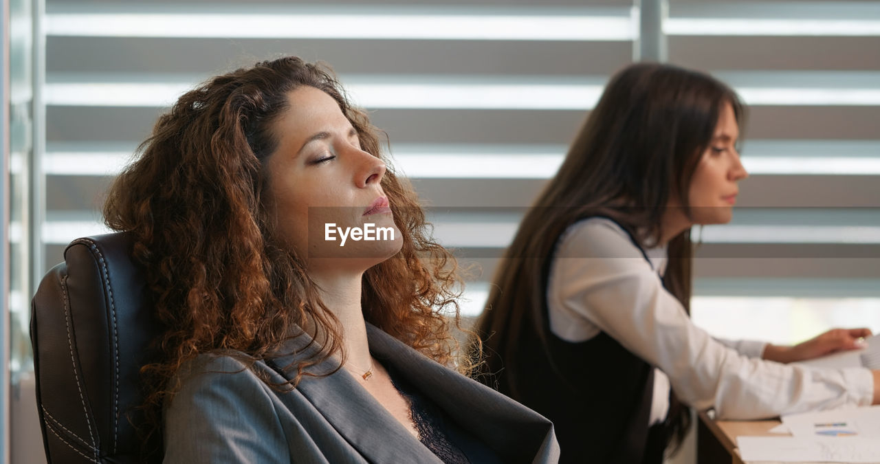 Business manager lying on her back tired of working relaxing in office.