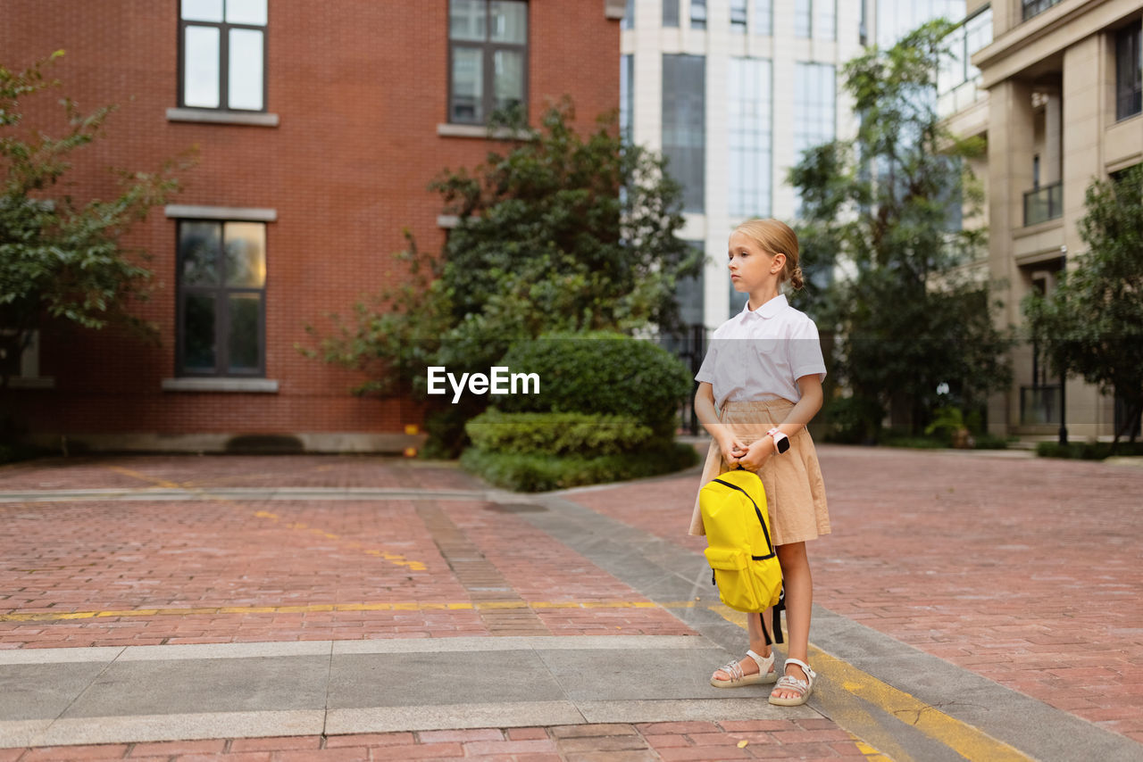 Full length of woman standing against building in city