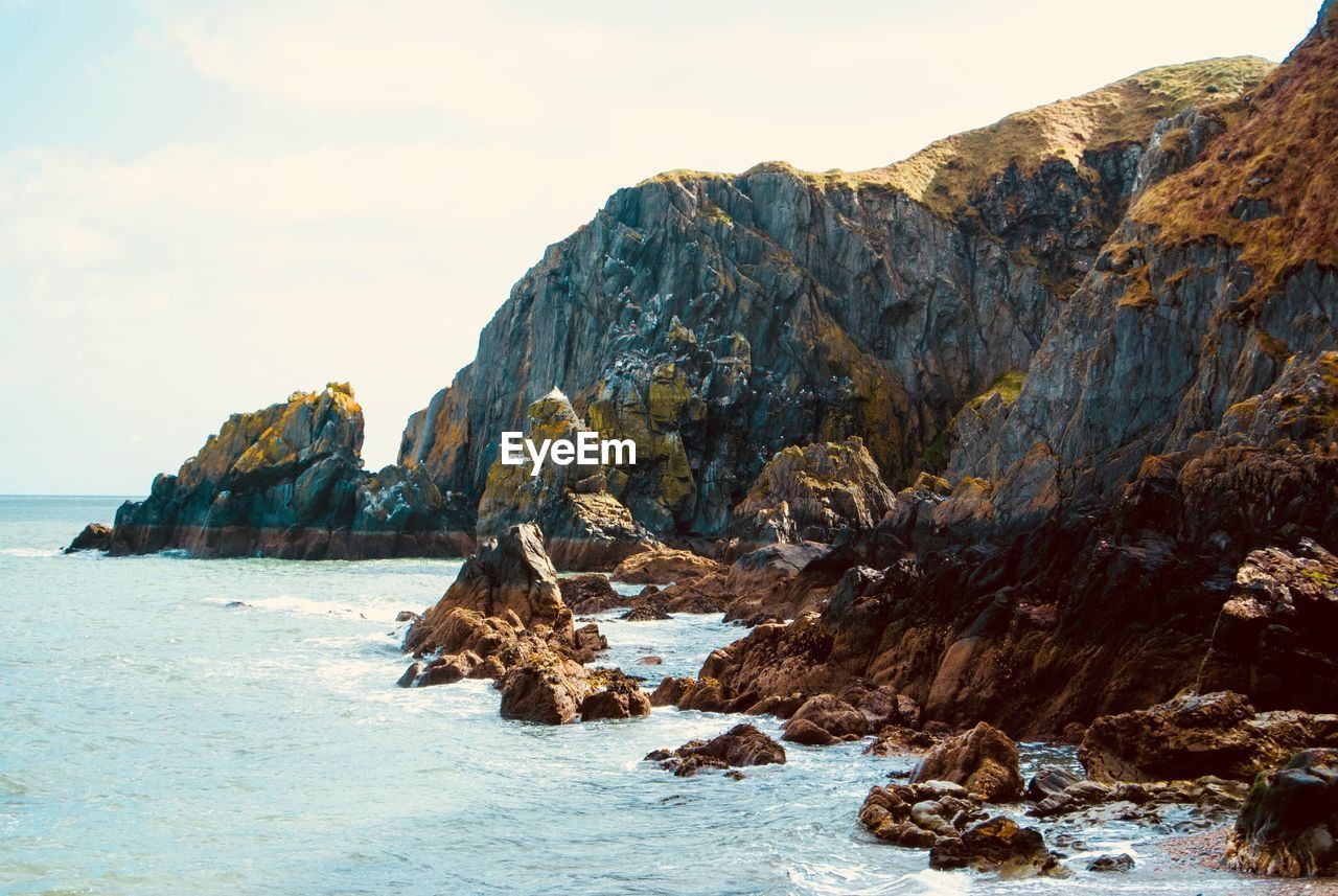 ROCKS IN SEA AGAINST SKY