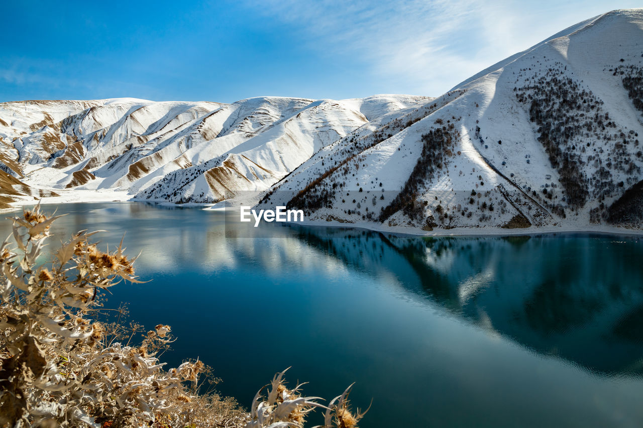 Lake kezenoy-am in the mountains in winter. scenic view of snowcapped mountains against sky