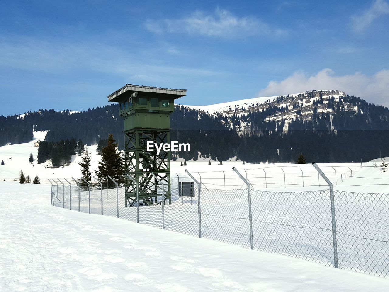 Lookout tower on snowcapped field during winter